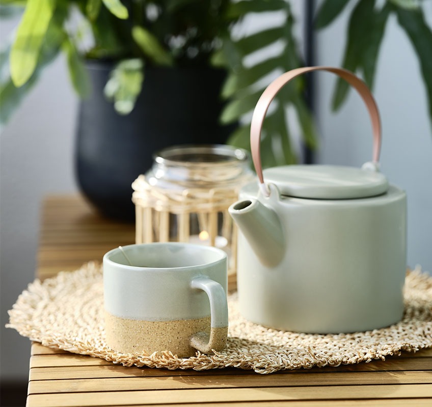 Garden bench with tea pot and mug placed on top