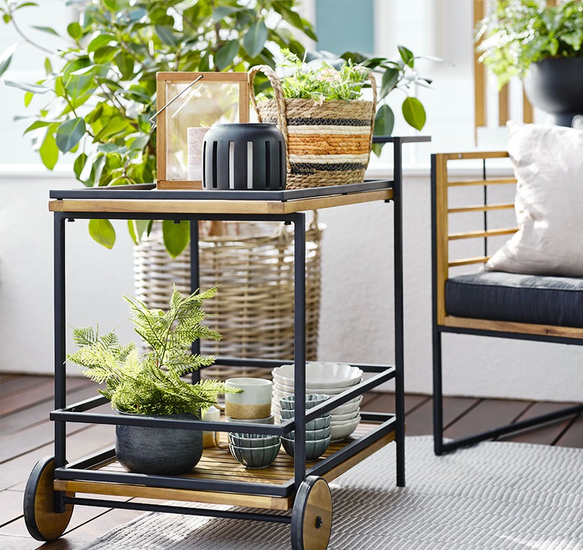 Balcony with outdoor bar trolley with lanterns, bowls, and plants