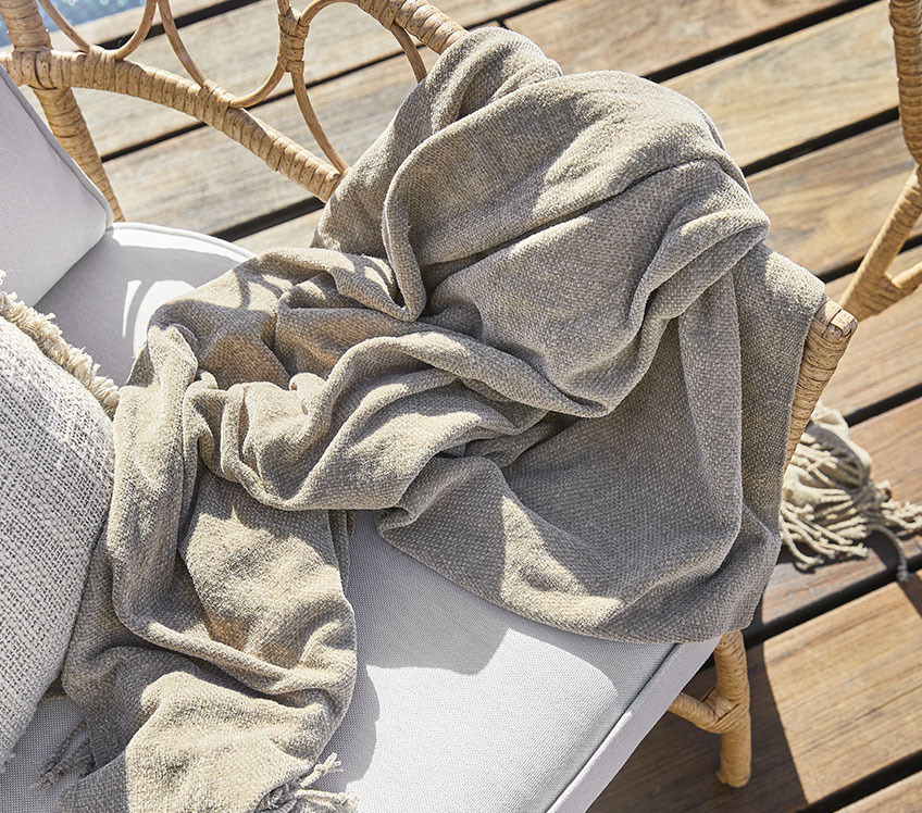 DUNHAVRE throw in JENNUM lounge chair Lounge chair with a khaki throw on a wooden patio