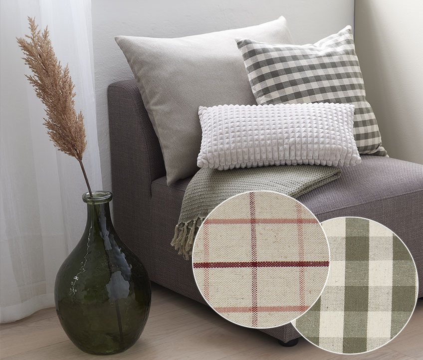 Grey, off white and checkered cushion in an armchair