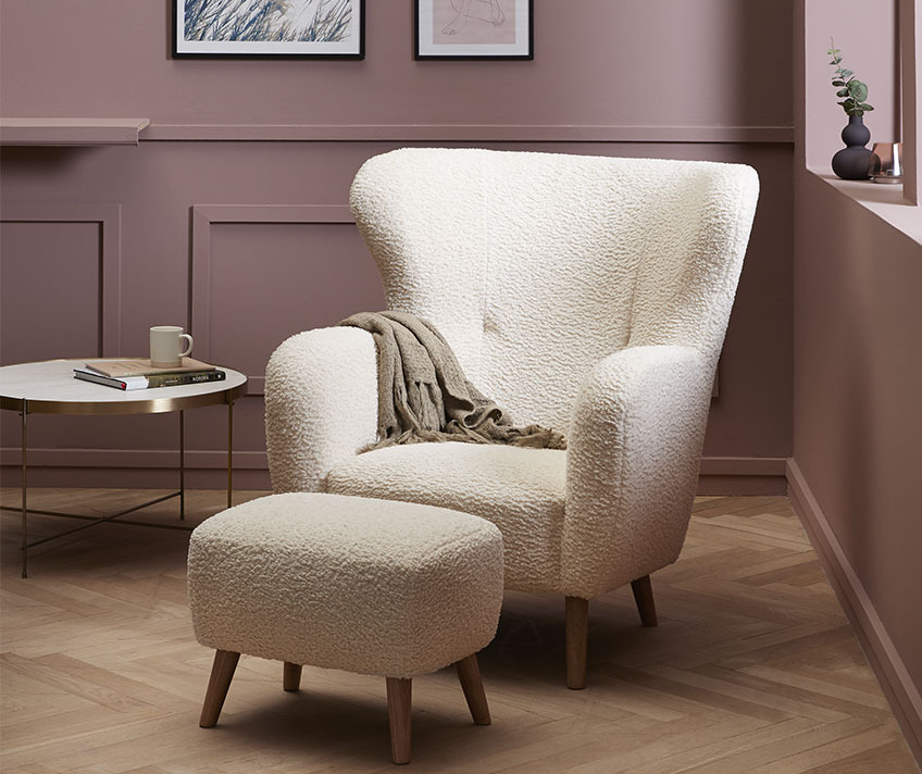White armchair and pouffe in teddy upholstery in a stylish living room