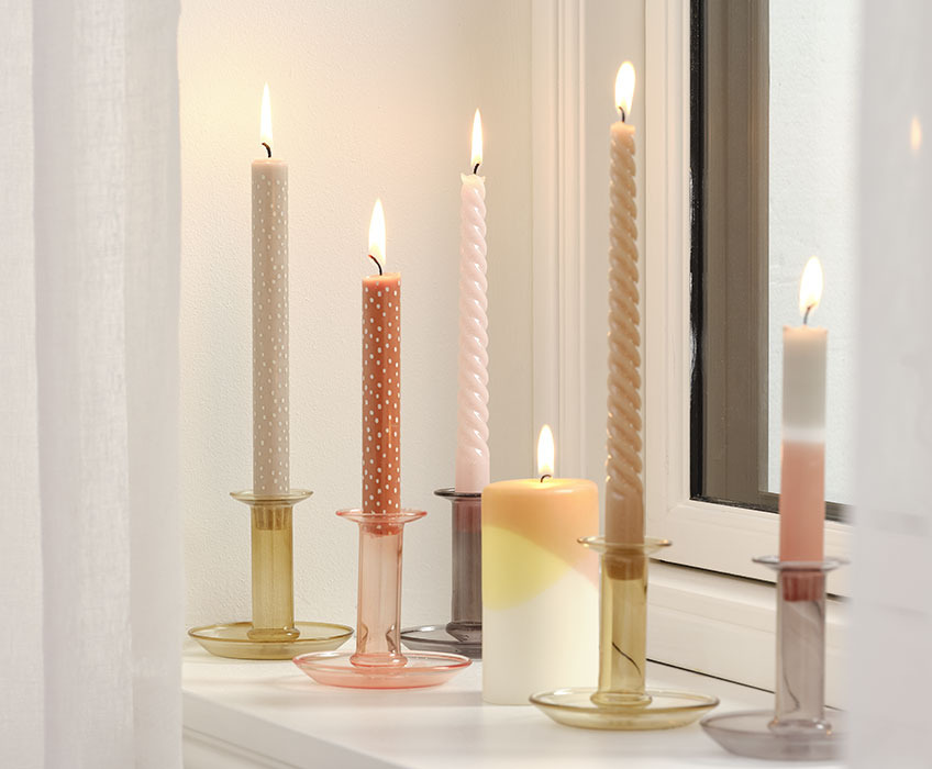 Candles in candlesticks in a windowsill 