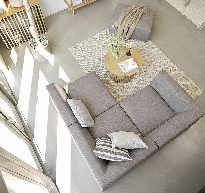 Grey modular sofa and round coffee table in Scandinavian living room