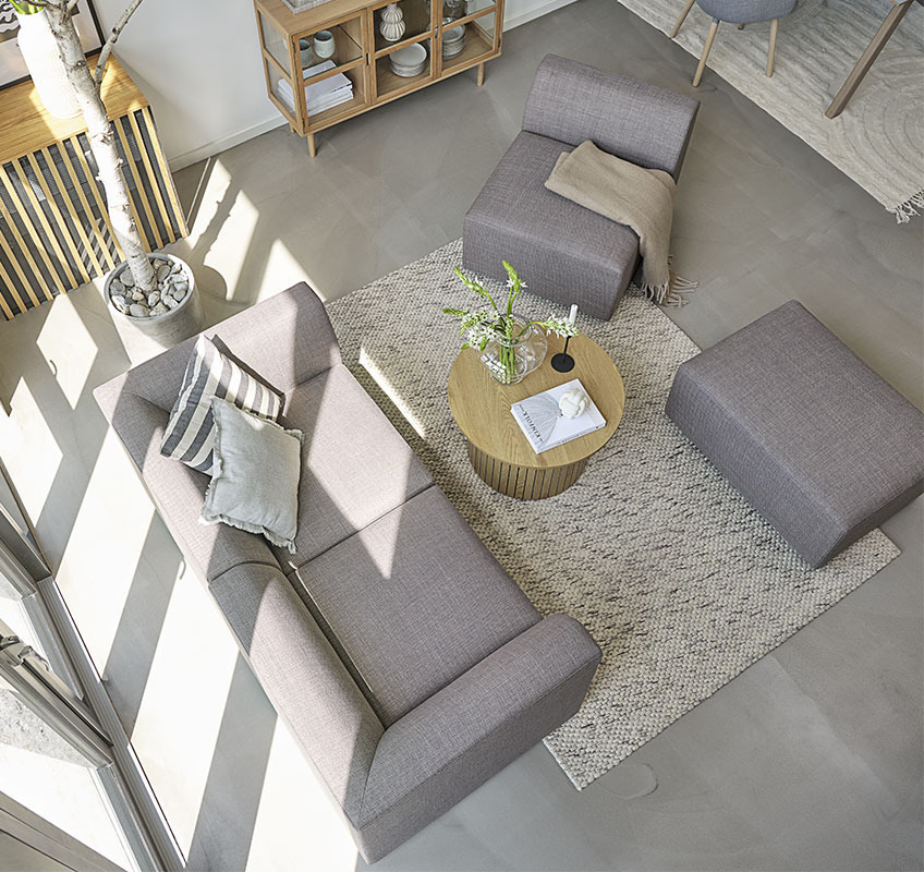 Grey modular sofa and round coffee table in Scandinavian living room