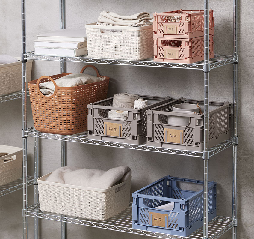 Blue, grey and coral plastic baskets on a shelving unit 