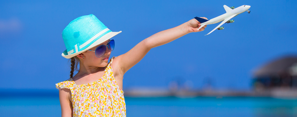 Girl holding toy airplane in the air