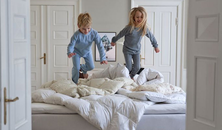 Children playing on a bed