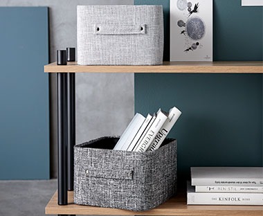 Grey fabric storage baskets on wooden shelving unit