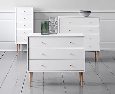a collection of white chest of drawers with three, four and five drawers